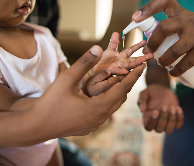toddler with hand sanitizer